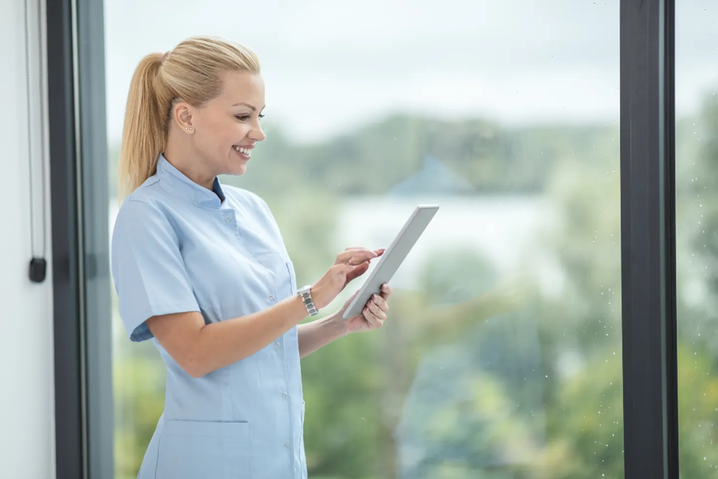 A healthcare professional reviewing facility details on a tablet.